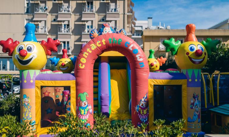 Gonfiabile colorato con clown sorridenti, atmosfera di festa e divertimento.