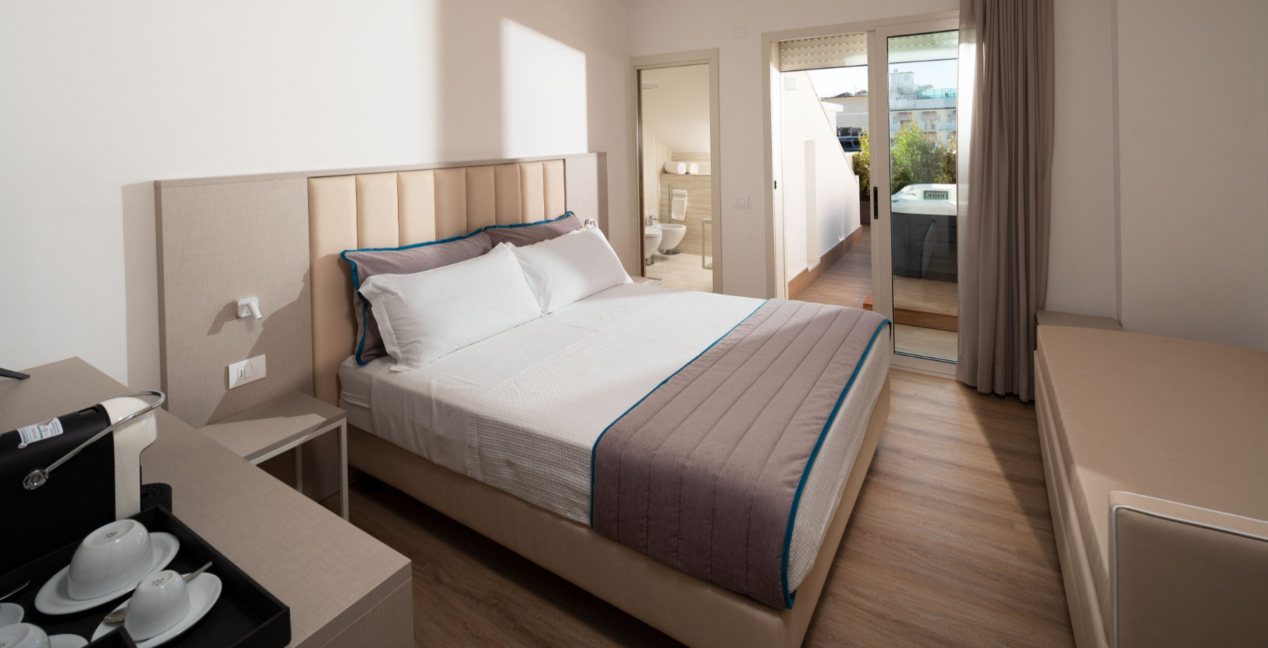 Camera moderna con letto matrimoniale, bagno privato e terrazza esterna.